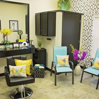 A stylish salon interior with vibrant chairs, decorative pillows, and a well-organized workspace.