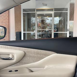 View from inside a car showing the entrance of a building.