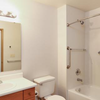 A clean, modern bathroom with a sink, toilet, and bathtub.