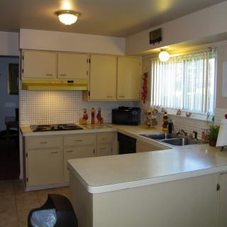 A small kitchen with cream-colored cabinets and a cozy setup.