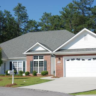 A suburban house with a well-maintained front yard and attached garage.