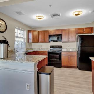 A modern kitchen interior with wooden cabinets and essential appliances.