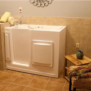 A bathroom featuring a walk-in tub, designed for accessibility and comfort, with towels neatly arranged on the side.