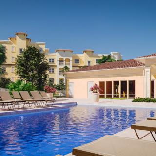 Luxurious resort pool with lounge chairs under a clear blue sky.