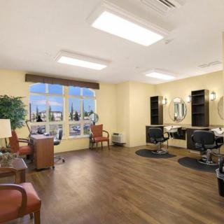 A well-lit salon interior with chairs, mirrors, and large windows.