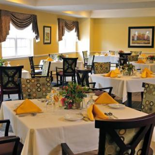A well-decorated restaurant interior with neatly arranged tables featuring yellow napkins.