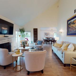 A stylish living room with comfortable seating, modern decor, and a connected dining area.