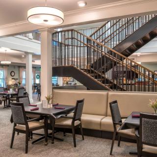 A modern dining area with elegant seating and a stylish staircase.