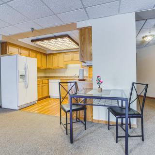 Spacious kitchen with wooden cabinets and a small dining table set.