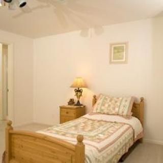 A simple bedroom with a single bed and nightstand.