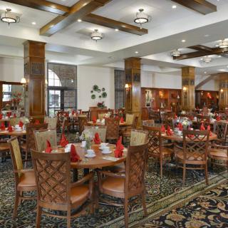 A spacious and elegantly decorated restaurant interior with neatly arranged tables and chairs.
