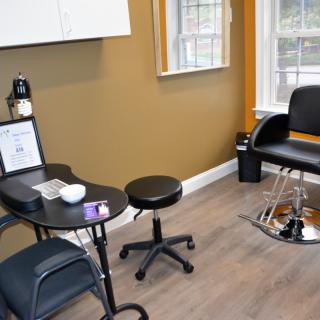 A neatly arranged salon interior with a barber chair and table.