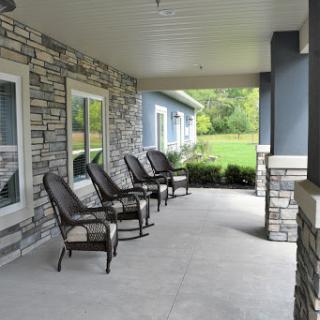 A serene porch area with comfortable chairs overlooking a lush lawn.