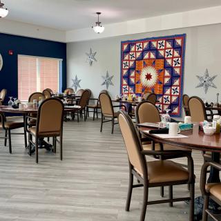 A modern dining room with neatly arranged tables and vibrant wall art.