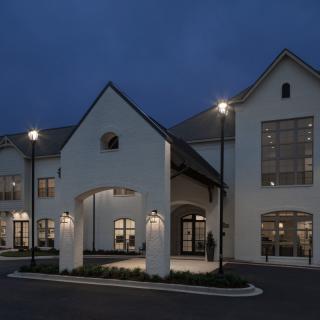 A modern building illuminated at night with exterior lights.