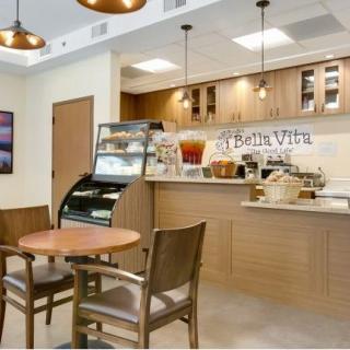 A cozy cafe interior with a small seating area and a counter displaying food and beverages.