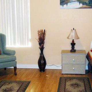 A cozy living room with a chair, side table, and decorative elements.