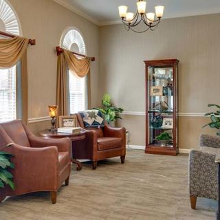 A cozy living room with comfortable armchairs, warm lighting, and elegant decor.