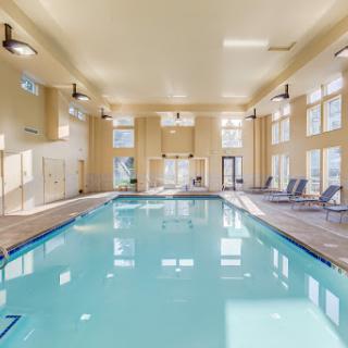 A serene indoor swimming pool, illuminated by natural light, perfect for relaxation and recreation.