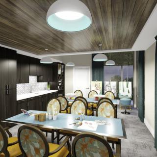 A modern dining area featuring upholstered chairs, a long table, and wooden ceiling with pendant lighting.