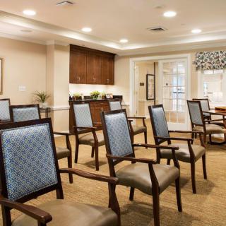 An empty conference room with neatly arranged chairs and warm lighting.
