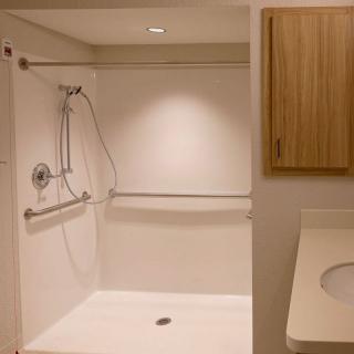 A modern, accessible shower with grab bars and a sleek design.