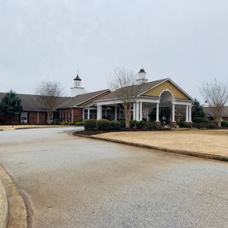 A residential building viewed from the entrance, set against a cloudy sky.