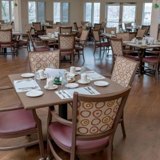 An empty dining room with neatly arranged tables and chairs.