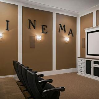 A cozy home theater setup with comfortable seating and a large projection screen.