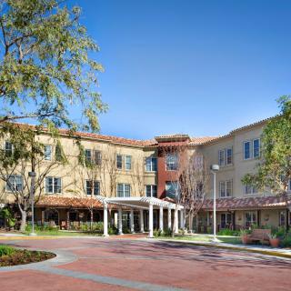 A residential building with a landscaped entrance and clear blue sky.