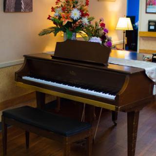 A beautifully arranged piano adorned with fresh flowers, set in a cozy interior space.