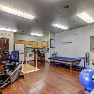 A well-equipped physical therapy room featuring various exercise equipment and a therapy bed.