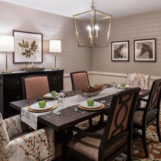 A well-decorated dining room featuring a large table with chairs, elegant lighting, and tasteful artwork on the walls.