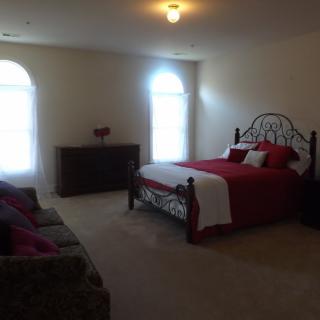 A cozy bedroom with a neatly made bed and simple furniture.