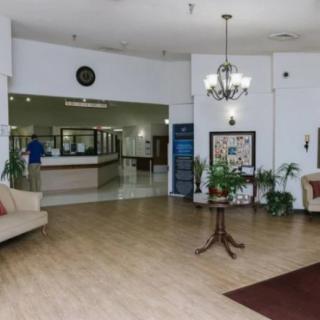 A spacious lobby area with a reception desk, comfortable seating, and decorative plants.