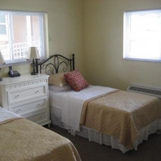 A cozy bedroom with twin beds and a white dresser.