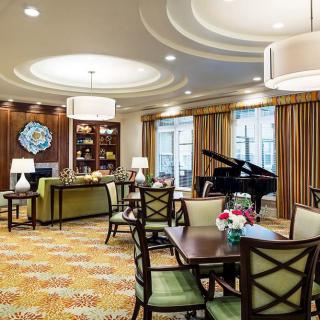 A cozy living and dining area featuring elegant furniture and a grand piano.