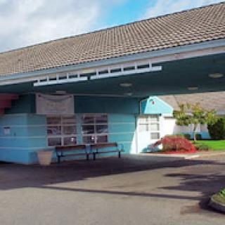 The entrance of a healthcare facility, showcasing a blue exterior and welcoming design.