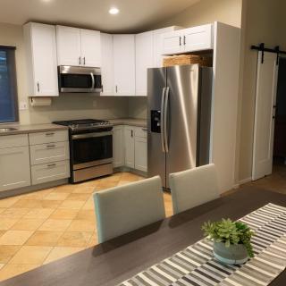 A modern kitchen and dining area with stainless steel appliances and white cabinets.
