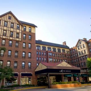 A brick hotel with a classic architectural design under a clear blue sky.