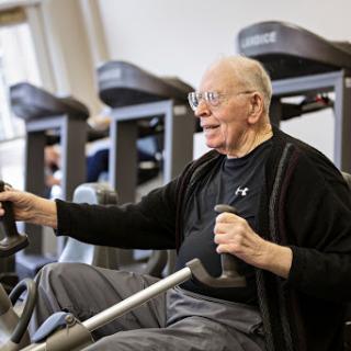 An elderly man enjoys a workout at the gym, demonstrating that fitness is for all ages.