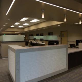 Modern office interior with cubicles and overhead lighting.