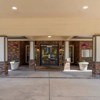 Entrance of a brick building with columns and planters.
