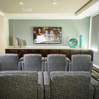 A cozy home theater setup with comfortable seating and a large TV.