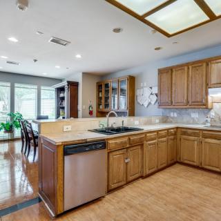 A spacious, modern kitchen with wood cabinetry and stainless steel appliances.