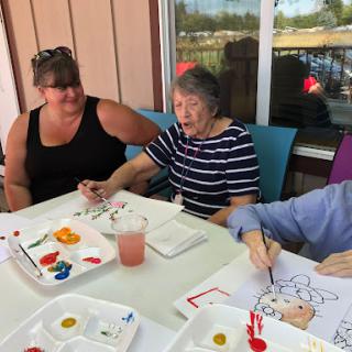 Seniors enjoying a fun painting session together, fostering creativity and companionship.