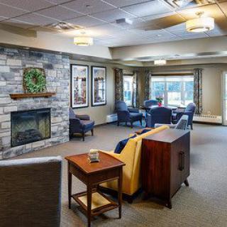 A cozy living room with a stone fireplace and comfortable seating.