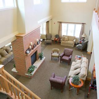 A spacious living room with a fireplace, multiple sofas and chairs, and large windows.