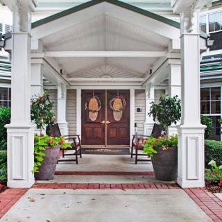 Welcoming entrance with double doors and seating area.