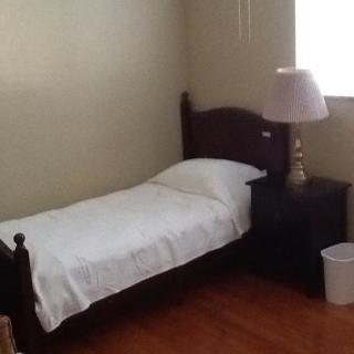 A minimalist bedroom with a single bed and nightstand.